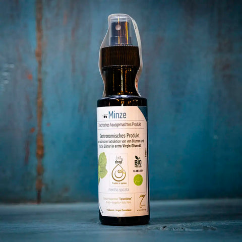 Just a drop Olivenöl Minze im blauen Ambiente – erfrischendes kaltgepresstes Olivenöl mit feiner Minznote, ideal für mediterrane Gerichte und Salate.