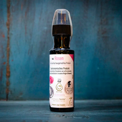 Just a drop Olivenöl Rose im blauen Ambiente – delikates kaltgepresstes Olivenöl mit zarter Rosennote, perfekt für mediterrane Gerichte und besondere Genussmomente.