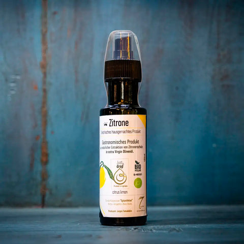 Just a drop Olivenöl Zitrone im blauen Ambiente – fruchtig-frisches kaltgepresstes Olivenöl mit intensiver Zitronennote, ideal für mediterrane Küche und Salate.