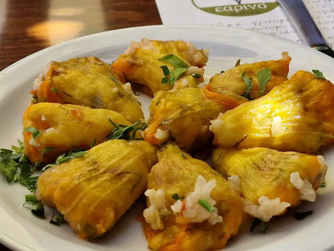 Gefüllte Zucchiniblüten als veganes Mezedes auf dem Teller angerichtet